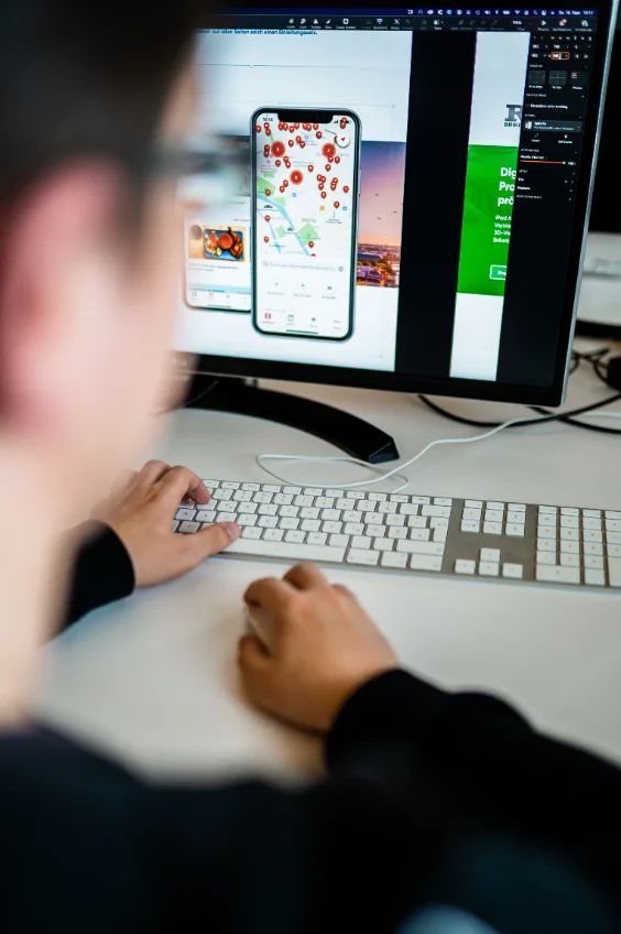 Entwickler am Arbeitsplatz mit App-Entwurf auf dem Bildschirm