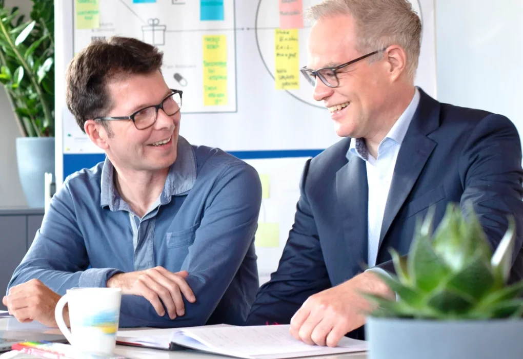 Zwei Kollegen von Werkdigital im Gespräch am Besprechungstisch
